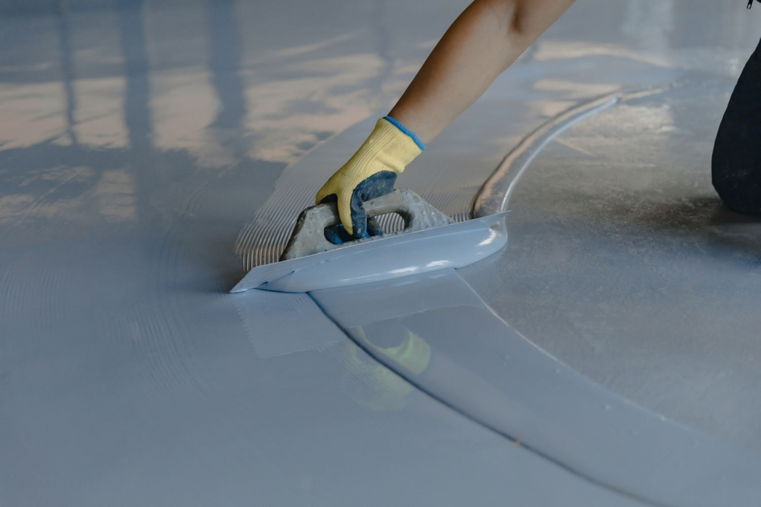Trowel application of a grey PU/epoxy cementitious floor system
