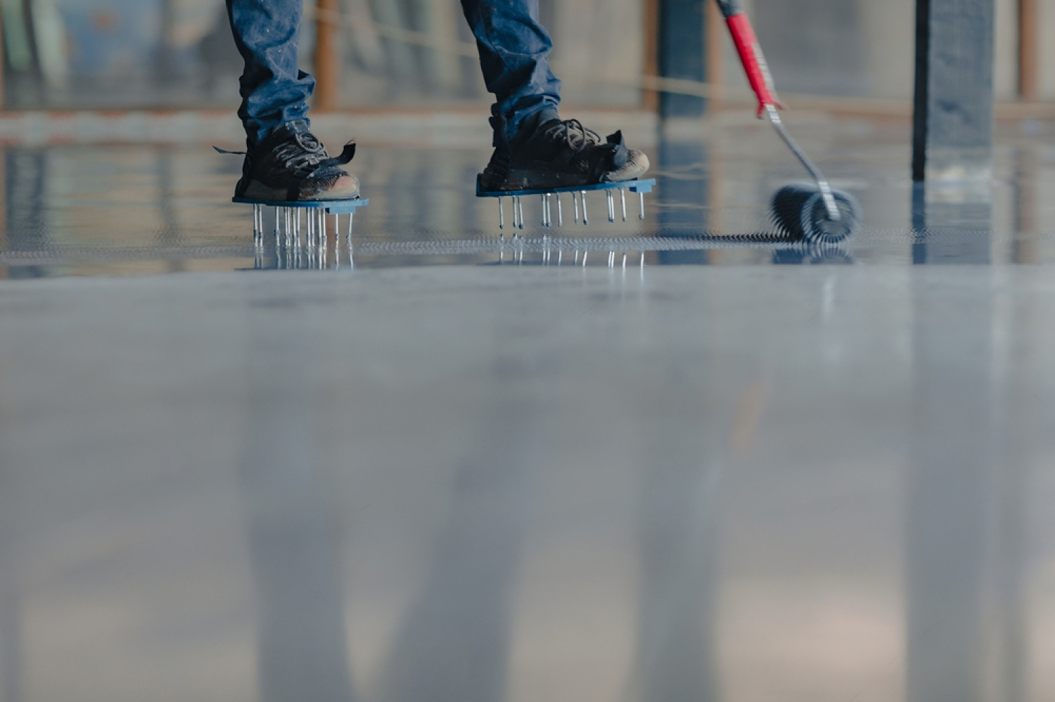 Spike-rolling a freshly laid resin floor to release trapped air