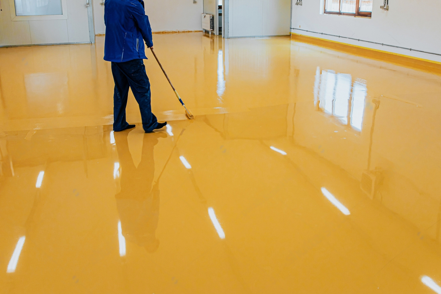 Roller application of a yellow self-level epoxy floor